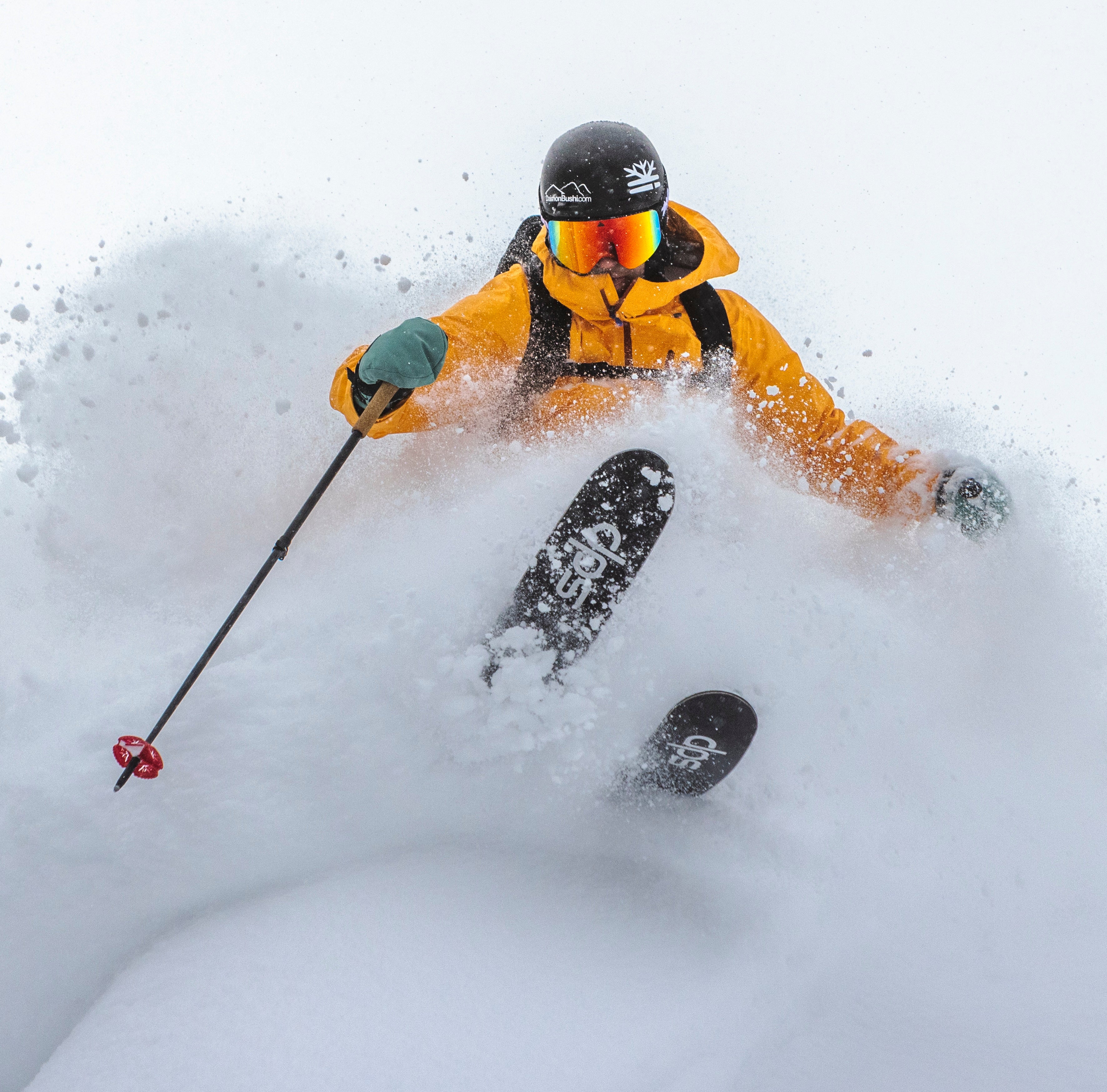 DPS Lotus powder skis floating in deep snow, rider in motion in Utah mountains, lightweight carbon performance.